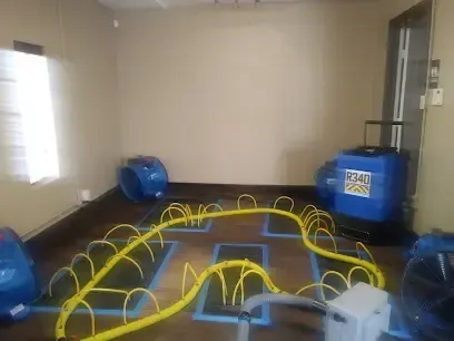 Drying mats and air movers pulling water from a wet floor