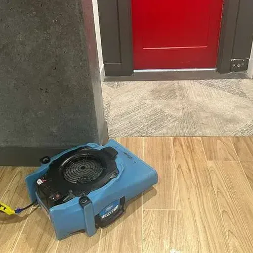 Air movers drying a room after a ceiling was opened below a roof leak