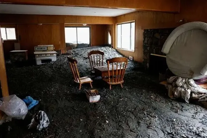Mud and debris left across a room after floodwater drained away